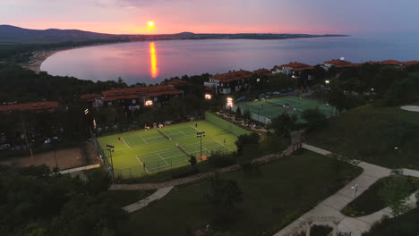 aerial,reverse,drone shot,red sunset and luxury tennis courts, in sozopol,black sea, on a beautiful sunset