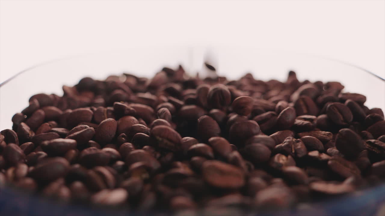 Nahaufnahme von Kaffeebohnen, die auf einen Haufen fallen - Makroaufnahme