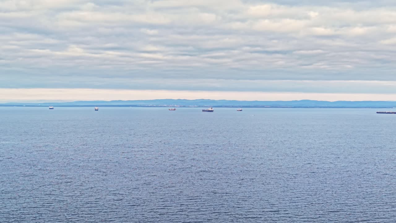 Vessel activity over calm waters under cloudy skies