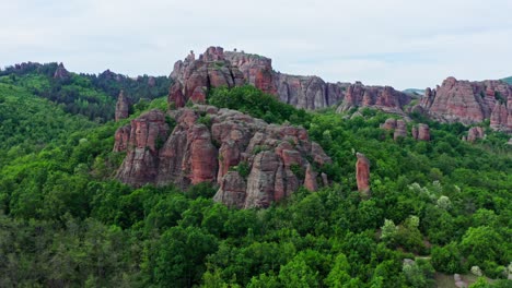 Drone-Vuela-Sobre-Bosques-Verdes-Hasta-El-Paisaje-De-Formaciones-Rocosas-De-Arenisca-De-Belogradchik