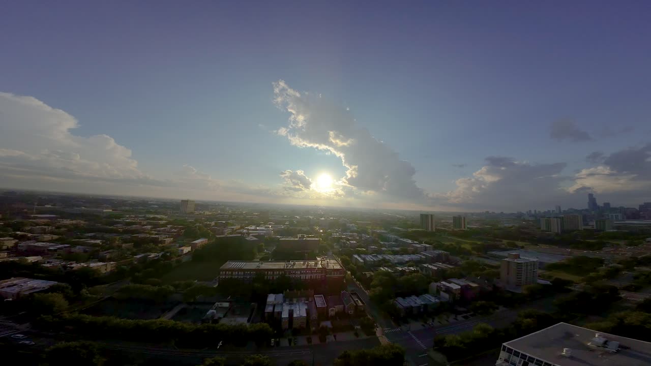 FPV aerial drone footage of a local Chicago neighborhood during sunset. the urban area is covered in a vibrant green forestry.