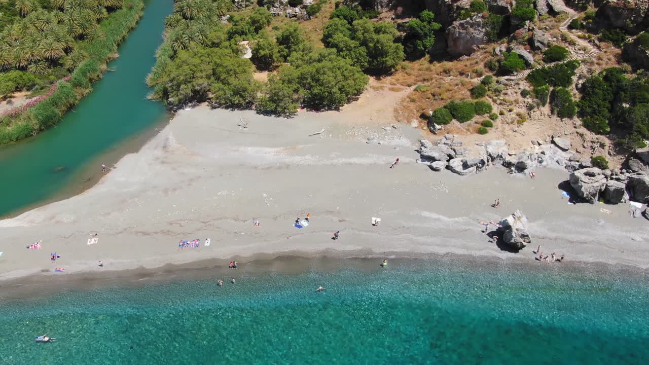 Tourists Relax On A Sandy Beach Inlet By The Ocean. Aerial Drone Shot Of Crete, Greece
