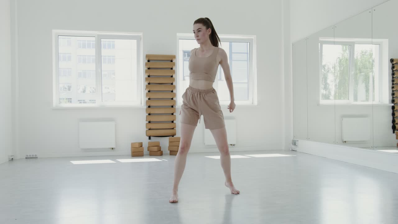 Donna in uno studio di danza, che esegue una posa di danza contemporanea.