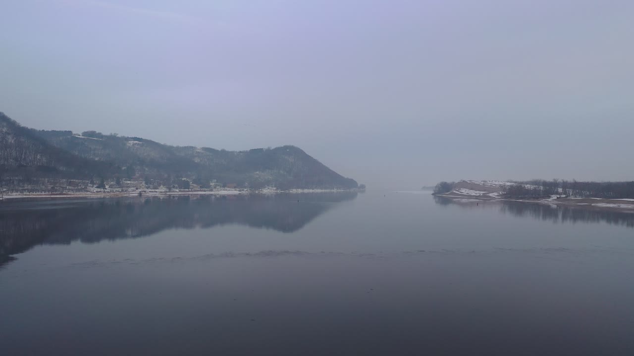 평온한 강과 안개가 가득한 산과 함께 겨울 풍경
