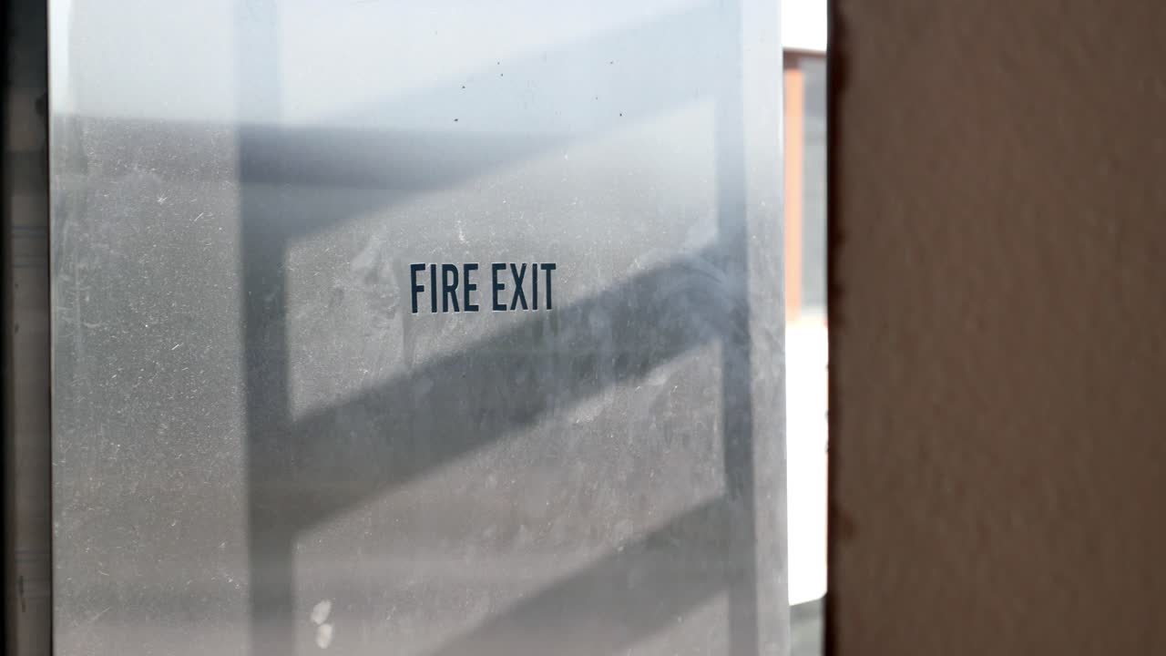 Close-up of a fire exit sign on a metal door