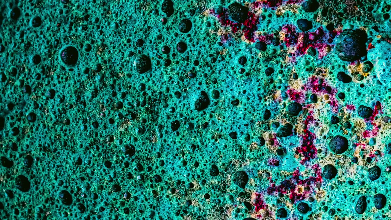 Vista macro astratta di superficie porosa testurizzata verde acqua e magenta