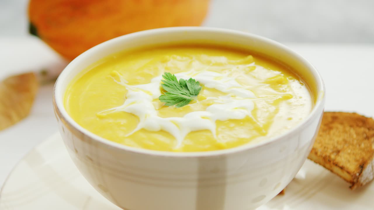 sopa de calabaza en tazón servida con pan