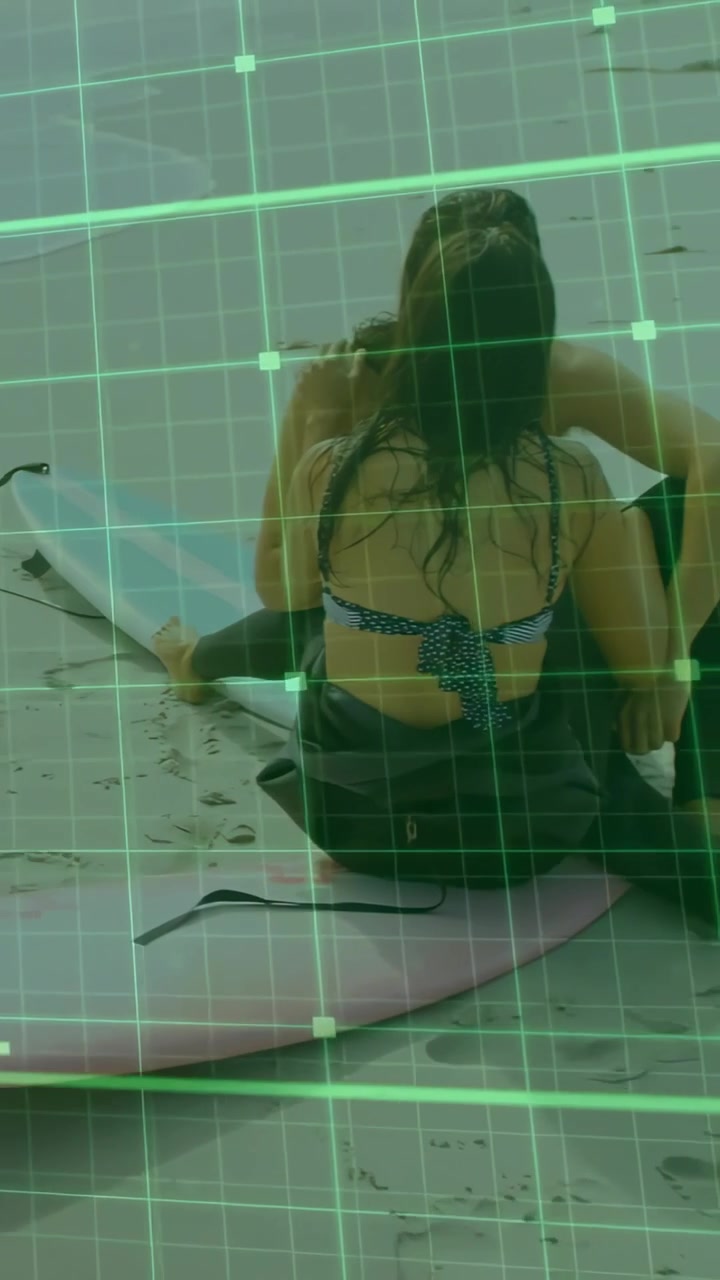 Vertical video: Woman adjusting leash and pulling suit, preparing to surf while green grid tracking