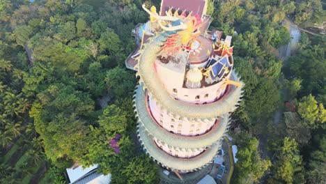 4k top down aerial cinematic footage panning around the wat samphran temple with huge dragon coiled around in amphoe sam phran province in bangkok, thailand