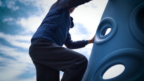 joven escalando un gran gimnasio de selva en cámara lenta