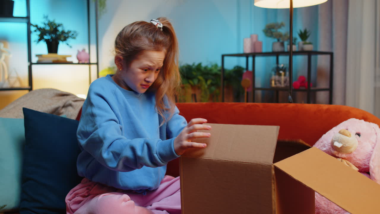 Angry dissatisfied shopper child girl kid unpacking parcel feeling upset confused wrong delivery