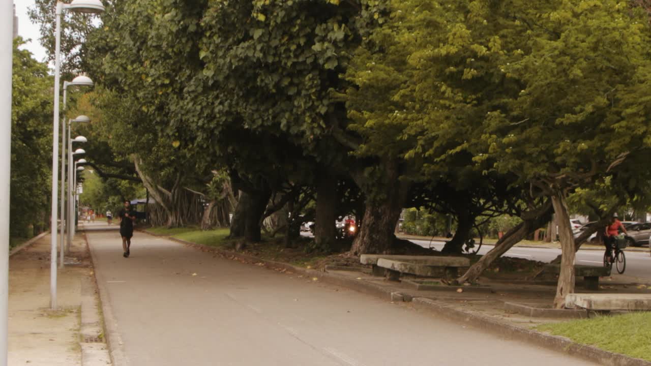 men running at Rodrigo de Freitas Lagoon on Epitacio Pessoa avenue in Rio de Janeiro