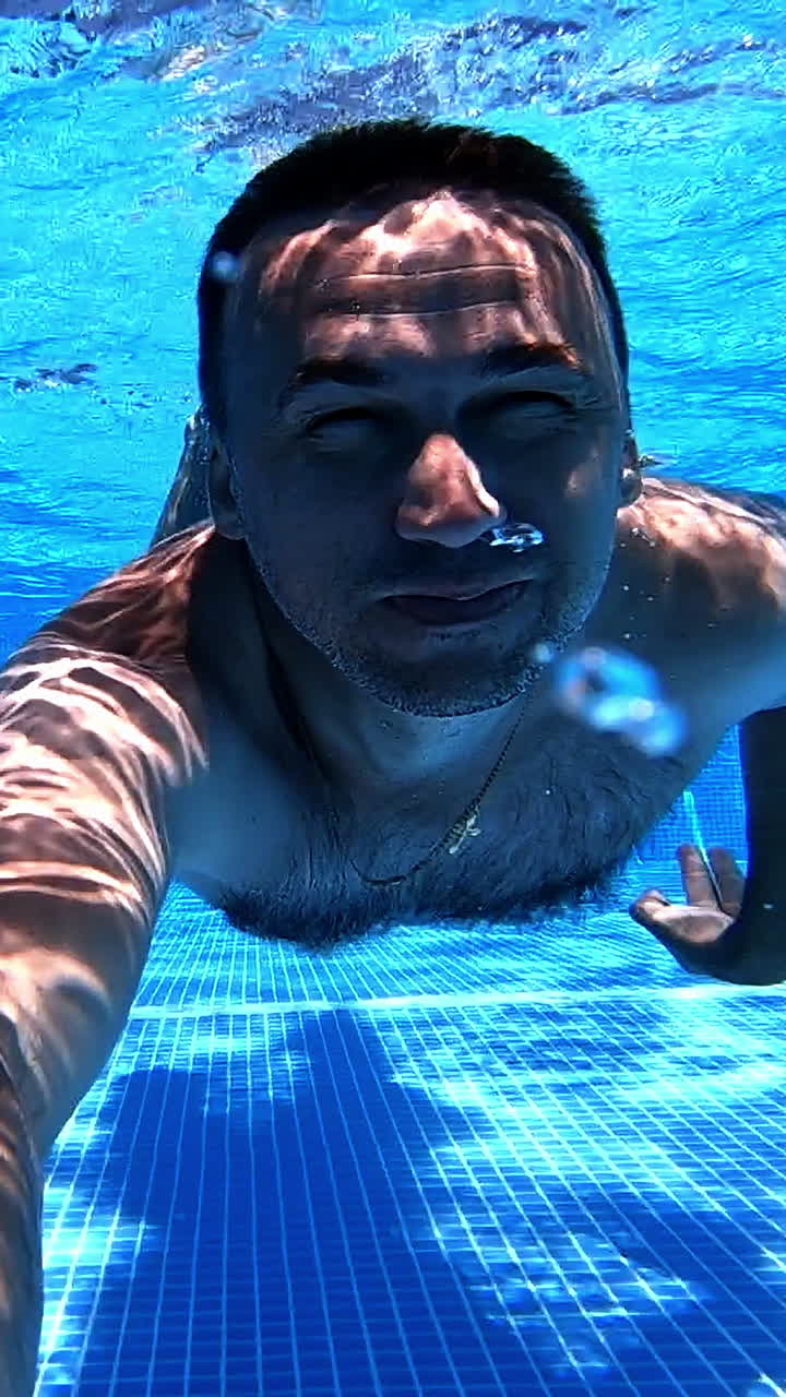 hombre nadando bajo el agua en una piscina