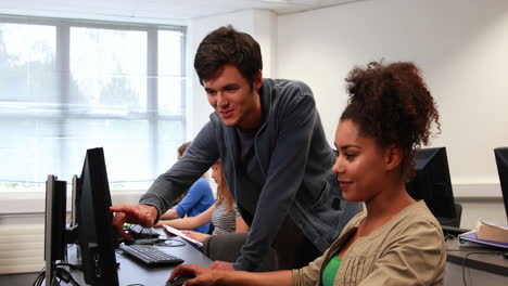 estudiantes trabajando juntos en la sala de computadoras