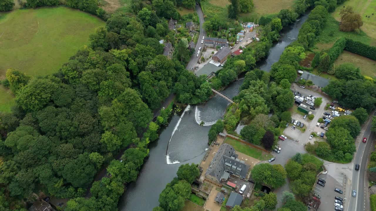 Aerial drone footage revealing heritage townscape and waterway in beautiful countryside, Derbyshire Dales, United Kingdom