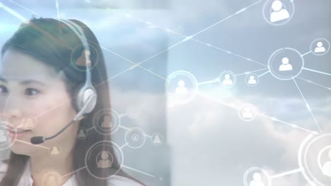 Animation-of-networks-of-connections-with-icons-over-businesswoman-using-phone-headsets