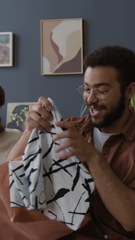 man unwrapping a gift with a friend