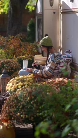 woman relaxing in a camping trailer during autumn