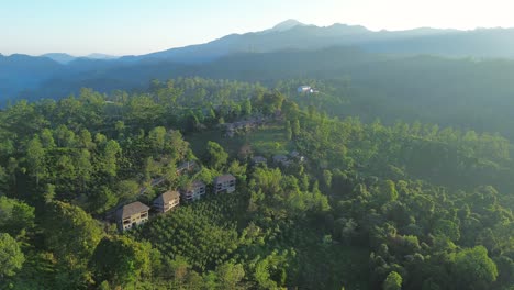 Paisaje-Aéreo-De-Drones-Del-Amanecer-De-La-Mañana-Sobre-Viviendas-En-Tierras-De-Cultivo-En-Un-Bosque-Natural-Con-Montañas-En-El-Fondo-El-Pico-Del-Pequeño-Adán-Ella-Sri-Lanka-Asia