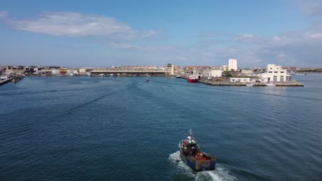 fishing boat arriving in peniche, portugal marina harbour - aerial drone view