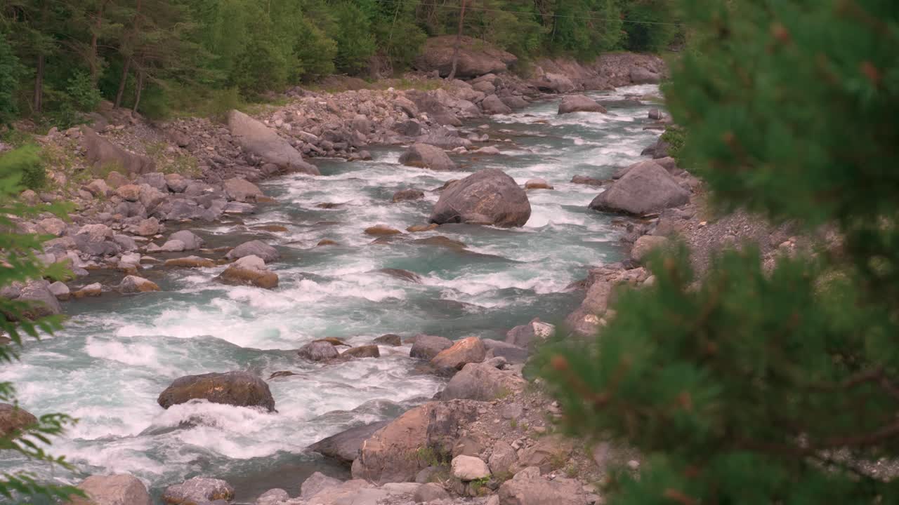 Vista dall'alto di un fiume azzurro e limpido, pieno d'acqua e rocce, che scorre attraverso la natura selvaggia in Francia