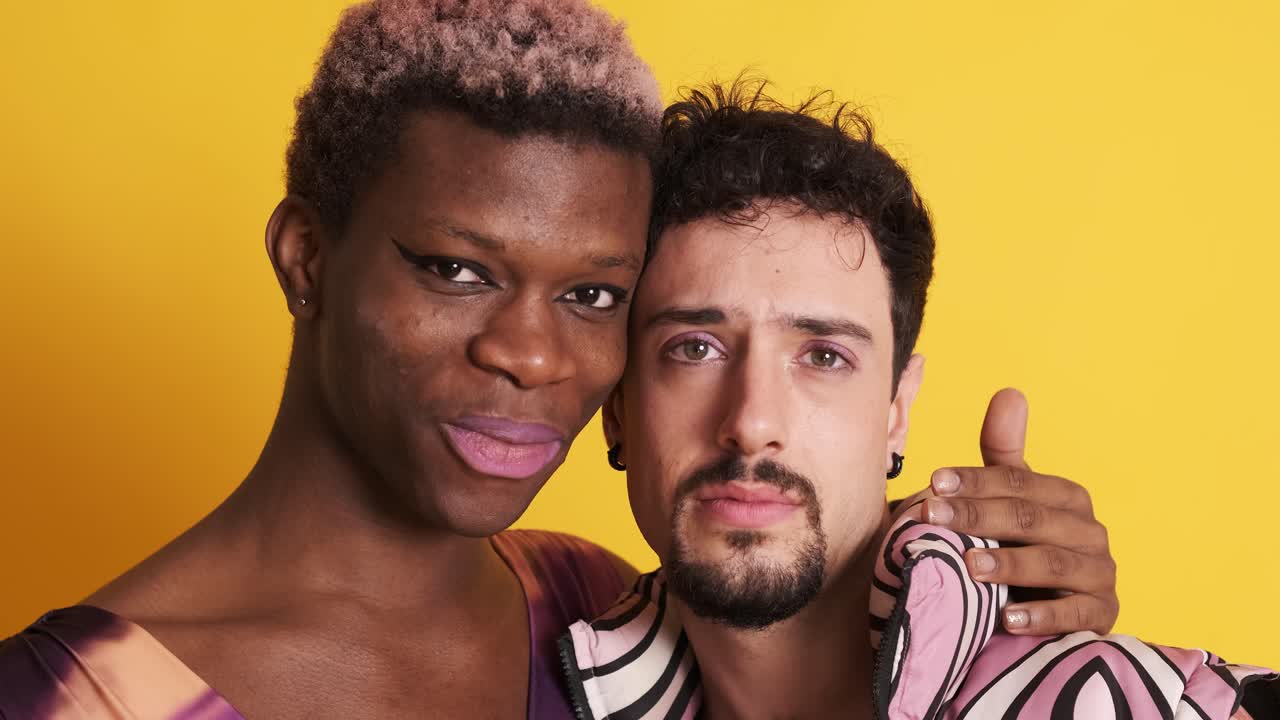 Cheerful transgender men smiling and embracing