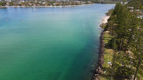 Turistas-Sentados-En-La-Alfombra-Bajo-Los-árboles-Cerca-Del-Arroyo-Tallebudgera---Stand-Up-Paddleboarding---Gold-Coast,-Queensland,-Australia