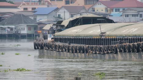 large green barge boat moving down a asian river