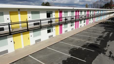 empty deserted unoccupied hotel motel in lancaster pa, pink and yellow doors, aerial dolly shot