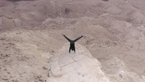 man performing handstand in a desert landscape