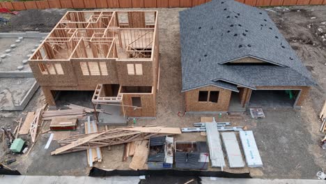 panning aerial shot of three homes in different stages of construction