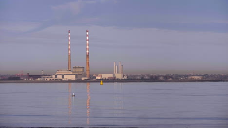 Seevögel-Schwimmen-Auf-Ruhiger-Wasseroberfläche-Mit-Industriehafen-Im-Hintergrund-In-Südirland-In-Der-Nähe-Von-Dublin