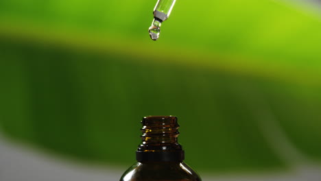 dropper pouring liquid drop on a bottle