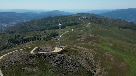 wind turbine rotating on top of a mountain overlooking gerês, renewable wind energy portugal