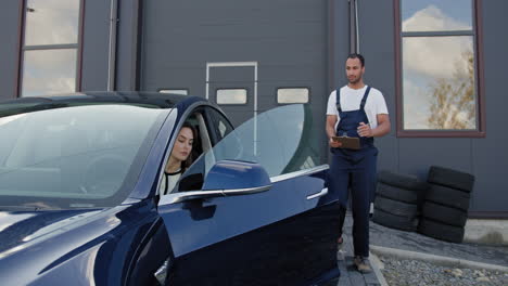 cliente discutiendo el servicio de automóviles con el mecánico