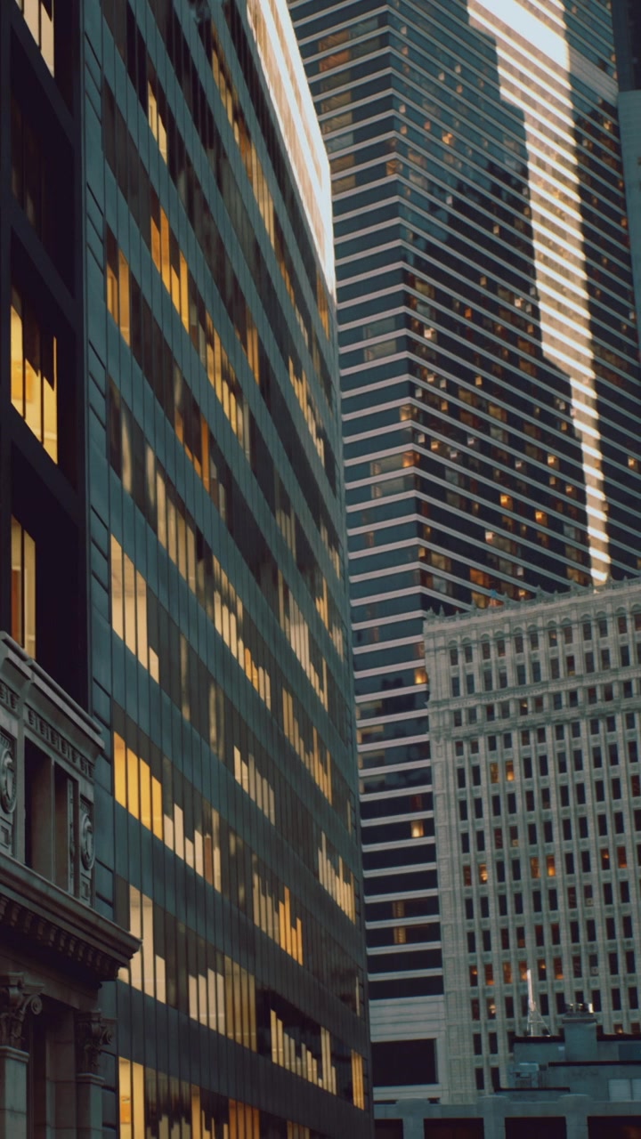 Edifícios refletem a luz em uma cidade durante o pôr do sol