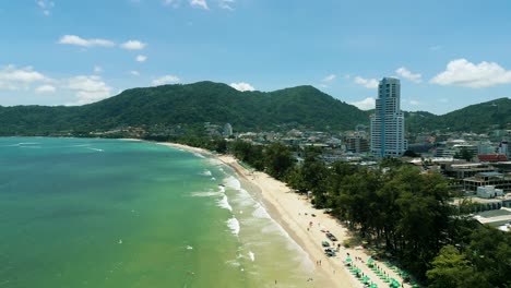 4K-Cinematic-nature-aerial-footage-of-a-drone-flying-over-the-beautiful-beach-of-Patong-in-Phuket,-Thailand-on-a-sunny-day