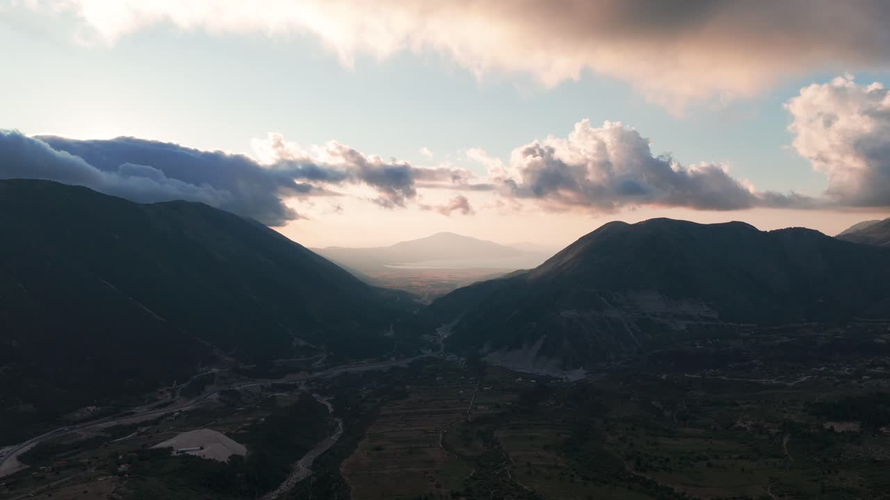 vista aérea panorámica del sombreado valle montañoso de albania durante la puesta de sol nublada