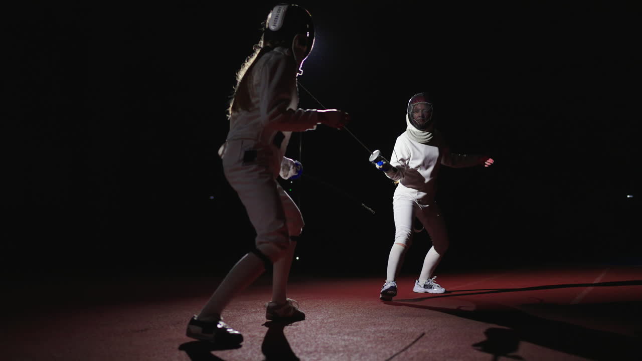 Two female fencers in a competition