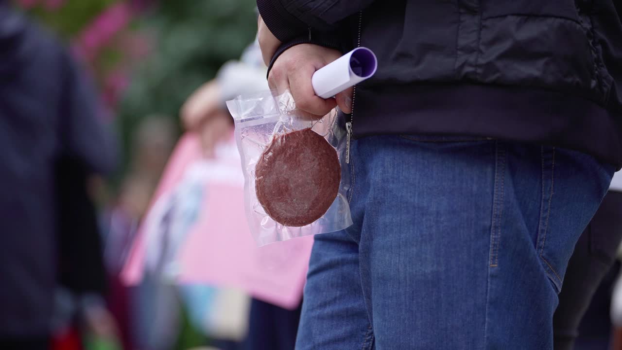 un hombre sostiene una chuleta vegana envasada. protesta contra el consumo de alimentos de origen animal.