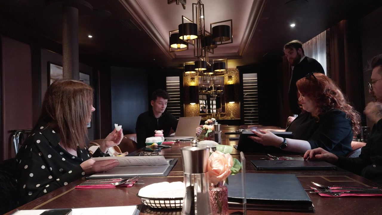 Family members gathered for dinner in an elegant restaurant private room, sharing conversation, connection and a warm celebratory mealtime atmosphere indoors