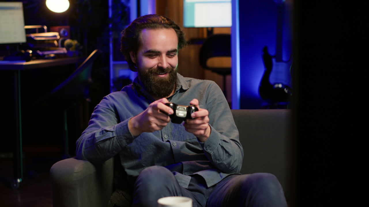 hombre disfrutando de jugar al videojuego en una habitación iluminada con neón, sosteniendo el controlador