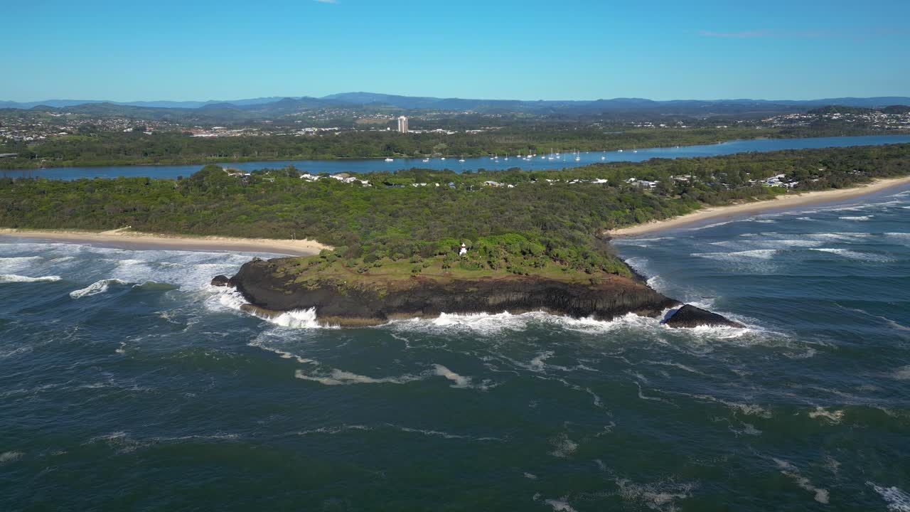 바위 가 있는 해안선 에 있는 등대 의 공중 사진