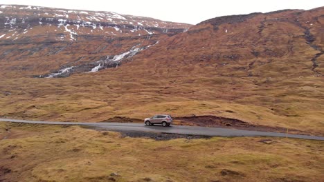 car driving through a vast and rugged mountain landscape