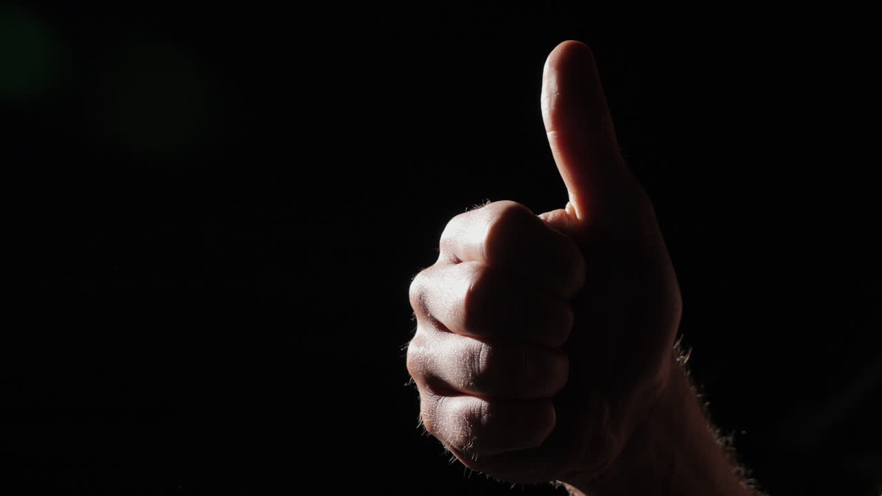 Close Isolated thumbs up on black background