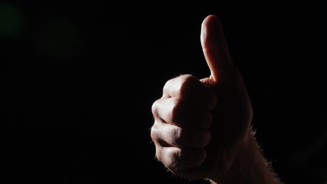 close isolated thumbs up on black background