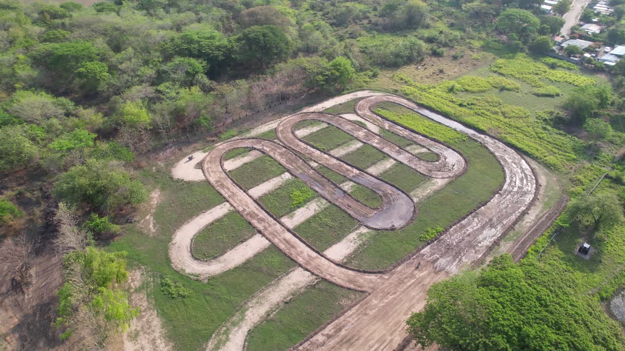 Top view of a winding dirt motocross track in green rural landscape, empty and peaceful
