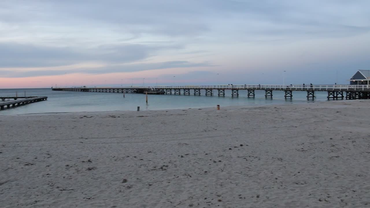 Tourists Walking on Busselton Jetty Pier at Sunset on Australia Beach