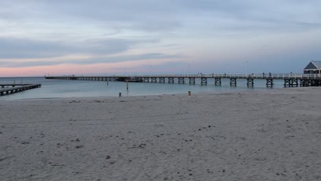 tourists walking on busselton jetty pier at sunset on australia beach