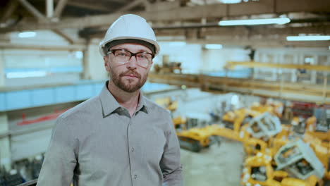 portrait of professional engineer in hard hat standing in industrial factory